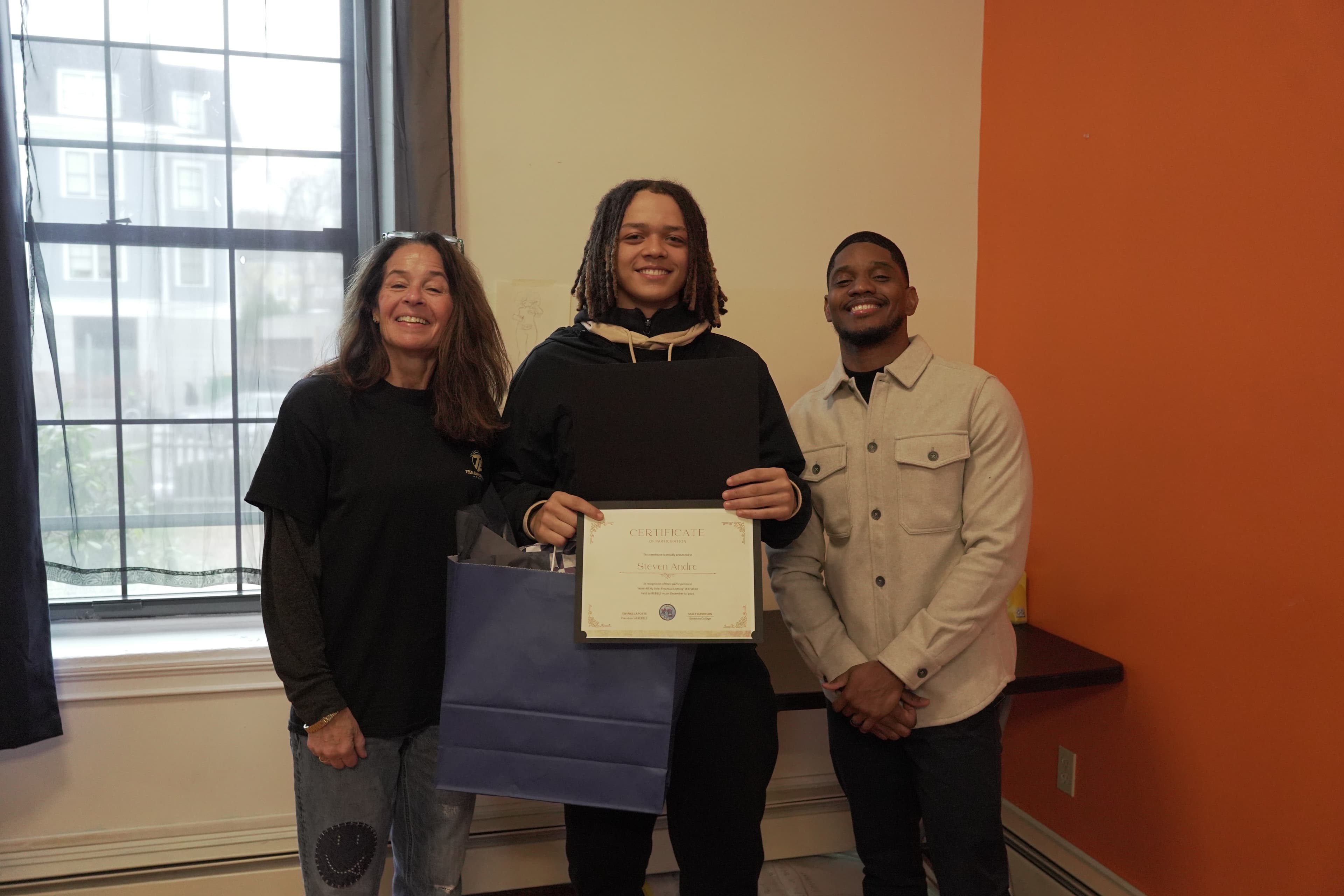 A REBELS graduate receiving their certificate during the cohort celebration